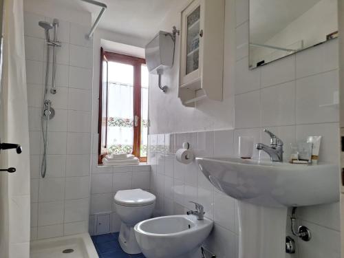 a white bathroom with a sink and a toilet at Casa Vacanze La Barca in Fiattone