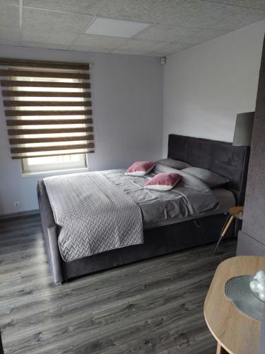 ein Schlafzimmer mit einem großen Bett und einem Tisch in der Unterkunft Piepilsēta in Alūksne