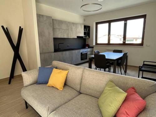 ein Wohnzimmer mit einem Sofa und bunten Kissen in der Unterkunft Sotto le Mura, appartamento Ponti in Siena