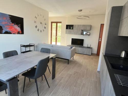 ein Wohnzimmer mit einem Tisch, einem Sofa und einer Uhr in der Unterkunft Sotto le Mura, appartamento Ponti in Siena