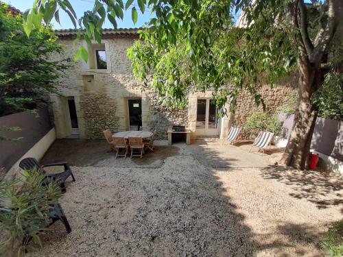 a patio with a table and chairs in front of a building at Gite Esprit Colibri in Pont-Saint-Esprit