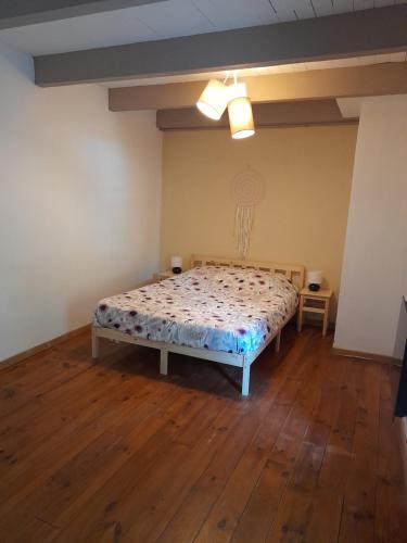 a bedroom with a bed and a wooden floor at Gite Esprit Colibri in Pont-Saint-Esprit