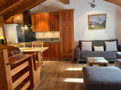 a kitchen and living room with a couch and a table at Ferienwohnung Chalet Püzji in Zermatt