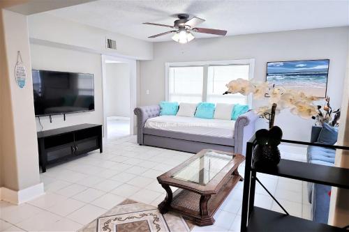 a living room with a couch and a flat screen tv at CasaAzul-2605A-Couples Retreat By Pleasure Pier, Beach, Seawall,a block away 5 Minutes from Strands and Cruise Terminal in Galveston