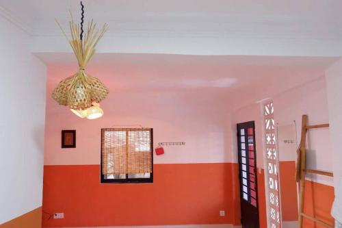 a room with a red wall and a chandelier at Tiny yet Beautiful apartment in the heart of Phnom Penh, Near central market in Phnom Penh