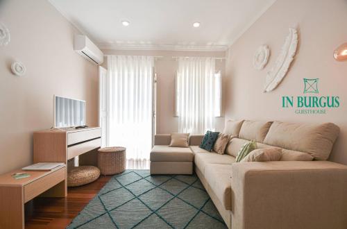 a living room with a couch and a tv at In Burgus guest house in Viana do Castelo