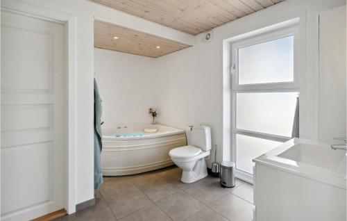 La salle de bains est pourvue d'une baignoire, de toilettes et d'un lavabo. dans l'établissement Cozy Home In Skrbk With Kitchen, à Skærbæk