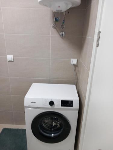 a washing machine in a bathroom with a sink at Apartmani Djuric Center in Subotica