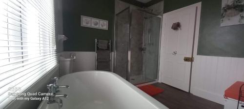 a bathroom with a bath tub and a shower at Rutland West Guest House in Filey
