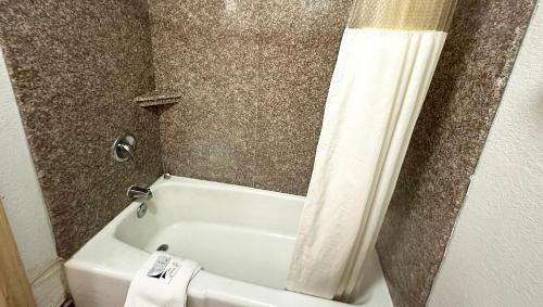 a bathroom with a white tub and a shower curtain at Apollo Lodge and RV Park in Fairfield