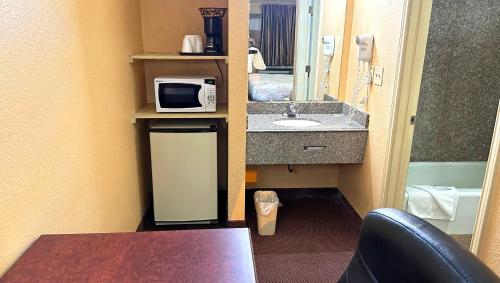 a small bathroom with a sink and a microwave at Apollo Lodge and RV Park in Fairfield