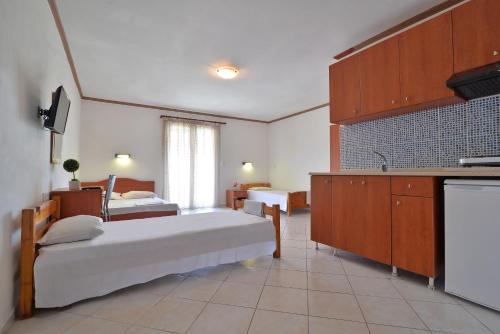 une grande chambre avec deux lits et une cuisine dans l'établissement Studio's Stelios, à Leptokaryá