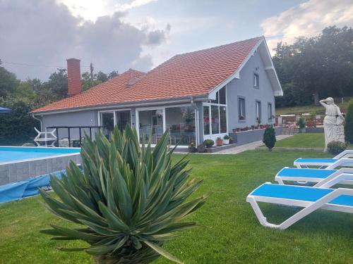 a house with two lounge chairs and a pool at Vila Boba Bor in Zlot