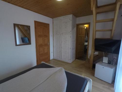 a bedroom with a bed and a room with a fireplace at Napsütötte Kehida in Kehidakustány