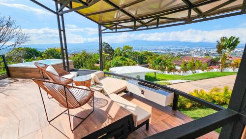 a patio with chairs and a table on a balcony at Alma Glamping in Escazu