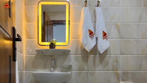 a bathroom with a sink and a mirror at Pyramids Tower view inn in Nazlat as Sammān