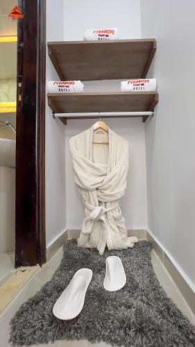a pair of white shoes sitting on a rug in a closet at Pyramids Tower view inn in Nazlat as Sammān