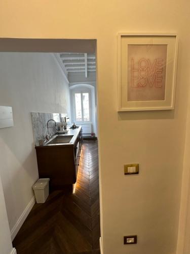 een keuken met een wastafel en een liefdesbord aan de muur bij Casa Orsi - appartamento fronte Duomo a Firenze in Florence
