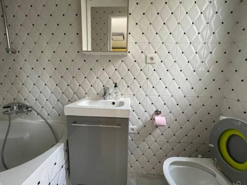 ein Badezimmer mit einem Waschbecken, einem WC und einem Spiegel in der Unterkunft Maison de ville,RER A 20 min pour Paris/Disneyland in Neuilly-sur-Marne