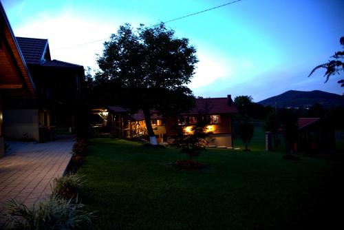 a house with the lights on in a yard at Brezova Poljana Lodge in Vrbovsko