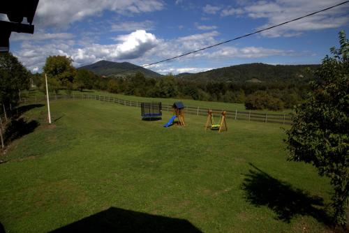 a large yard with two playground equipment in the grass at Brezova Poljana Lodge in Vrbovsko