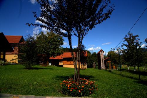 a tree in a bed of flowers in a yard at Brezova Poljana Lodge in Vrbovsko