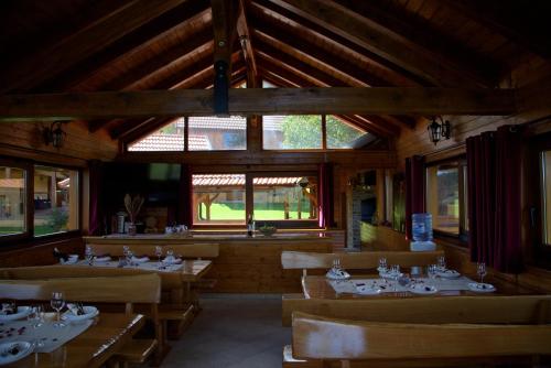 a dining room with tables and chairs and windows at Brezova Poljana Lodge in Vrbovsko