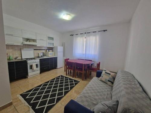 巴尼亞盧卡的住宿－Apartman Sofija，客厅配有沙发和餐桌,厨房配有桌子