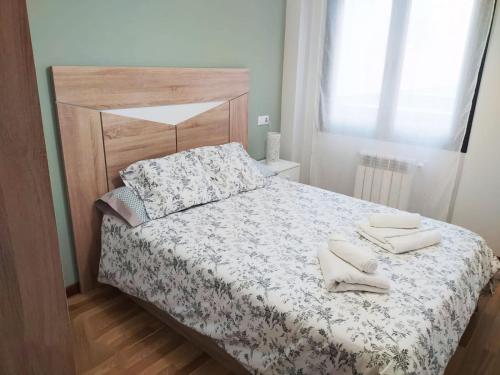 una camera da letto con un letto e due asciugamani di COQUETO APARTAMENTO EN OVIEDO a Oviedo