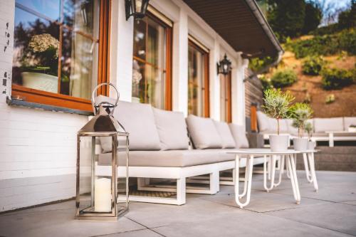 a white bench and a table on a porch at Landidyll Hotel Restaurant Weidenbrück & SPA in Swisttal