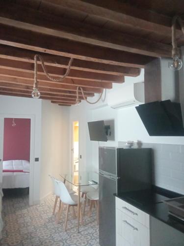 a kitchen with a table and chairs in a room at SEÑORÍO DE ORGAZ III in Toledo