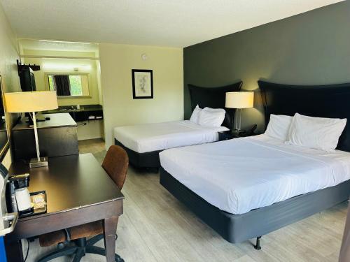 una camera d'albergo con 2 letti e una scrivania di Rodeway Inn a Silver Springs