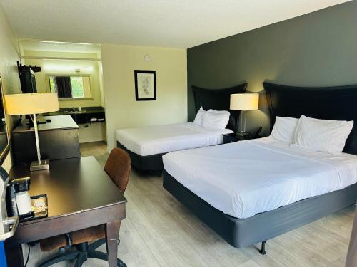 a hotel room with two beds and a desk at Rodeway Inn in Silver Springs