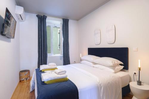 een slaapkamer met een groot wit bed en handdoeken bij Paxos Fairytales House 1 in Gaios