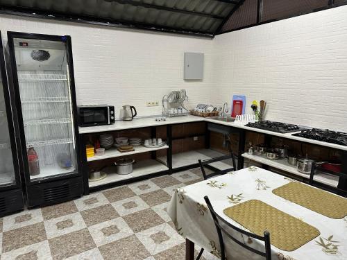 a kitchen with a table and a stove and a refrigerator at KUKARACHA in Ureki