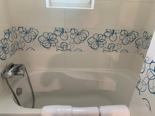 a bathroom with a tub with a flower pattern on the wall at Nad rzeką in Piła