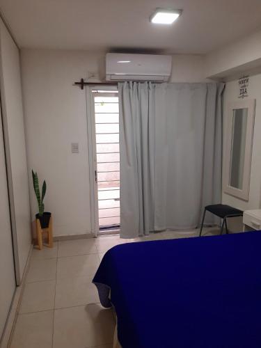 Un dormitorio con una cama azul y una ventana en Hermoso departamento céntrico! en San Miguel de Tucumán