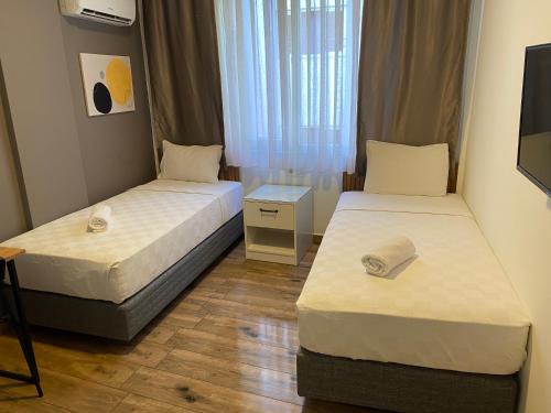 two beds in a small room with a window at Turunç Hotel ANTALYA in Antalya