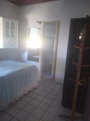 1 dormitorio con cama, ventana y escalera en Condomínio Amanda Travassos en Jaguaribe