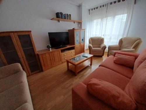 a living room with a couch and a tv at Raquel Inn - Garaje incluido in Avilés