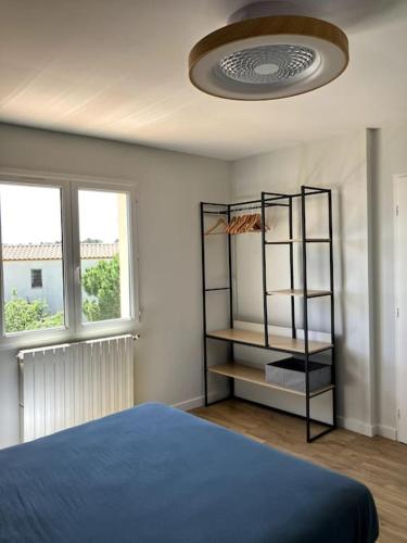- une chambre avec un lit bleu et une étagère dans l'établissement Grande Maison familiale Leucate vue mer et village, à Leucate