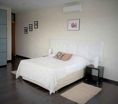 a bedroom with a bed with a white bedspread and two lamps at Retiro da cegonha in Crato