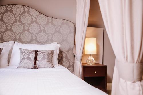 1 dormitorio con 1 cama blanca con dosel en Boutique Hotel Municipio 1815, en Valdobbiadene