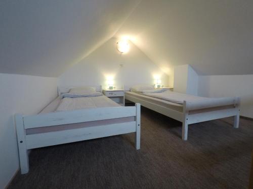 duas camas num pequeno quarto com duas lâmpadas em Napsütötte Kehida em Kehidakustány
