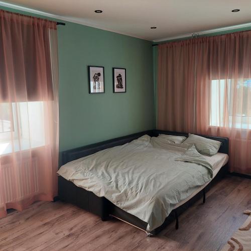 1 cama en un dormitorio con paredes y ventanas verdes en TT majutus en Tapa