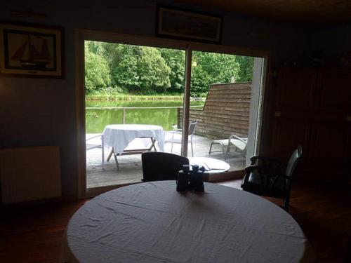 une salle à manger avec une table et une vue sur un patio dans l'établissement La Suite du Pêcheur, balnéo et terrasse privative. Entre terre et mer, à Tréméoc