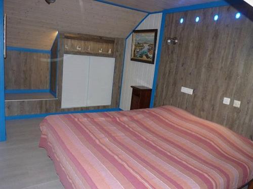 1 dormitorio con 1 cama grande con manta a rayas en La Suite du Pêcheur, balnéo et terrasse privative. Entre terre et mer, en Tréméoc
