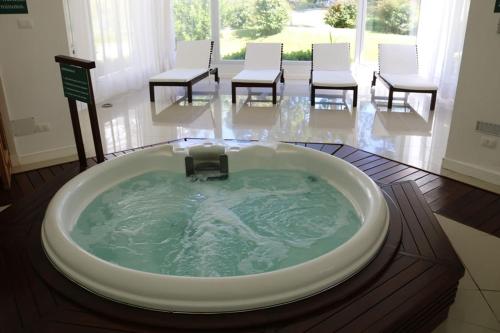 a jacuzzi tub in a room with tables and chairs at Monoambiente Green Park- Solanas in Punta del Este