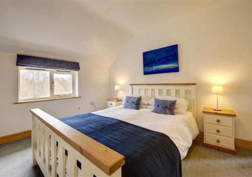 Kettleburgh的住宿－Akenfield Cottage, Letheringham，一间卧室设有一张大床和两个窗户。