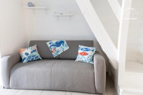 a gray couch with two pillows on it in a room at Carpe Diem House in Bacoli